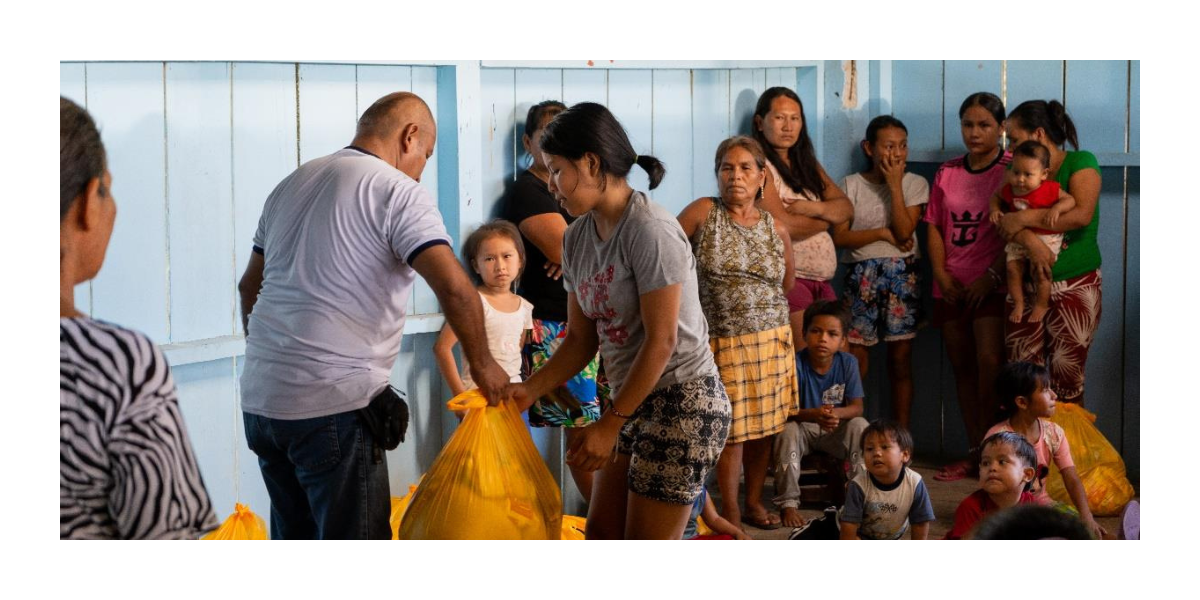 A man hands a woman a bag of supplies