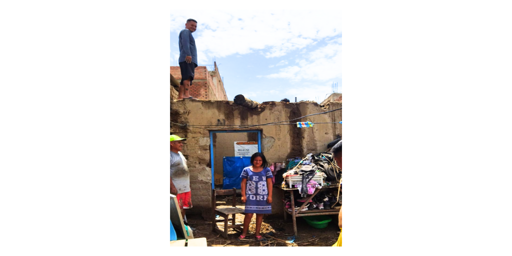 girl standing near damaged house in Peru