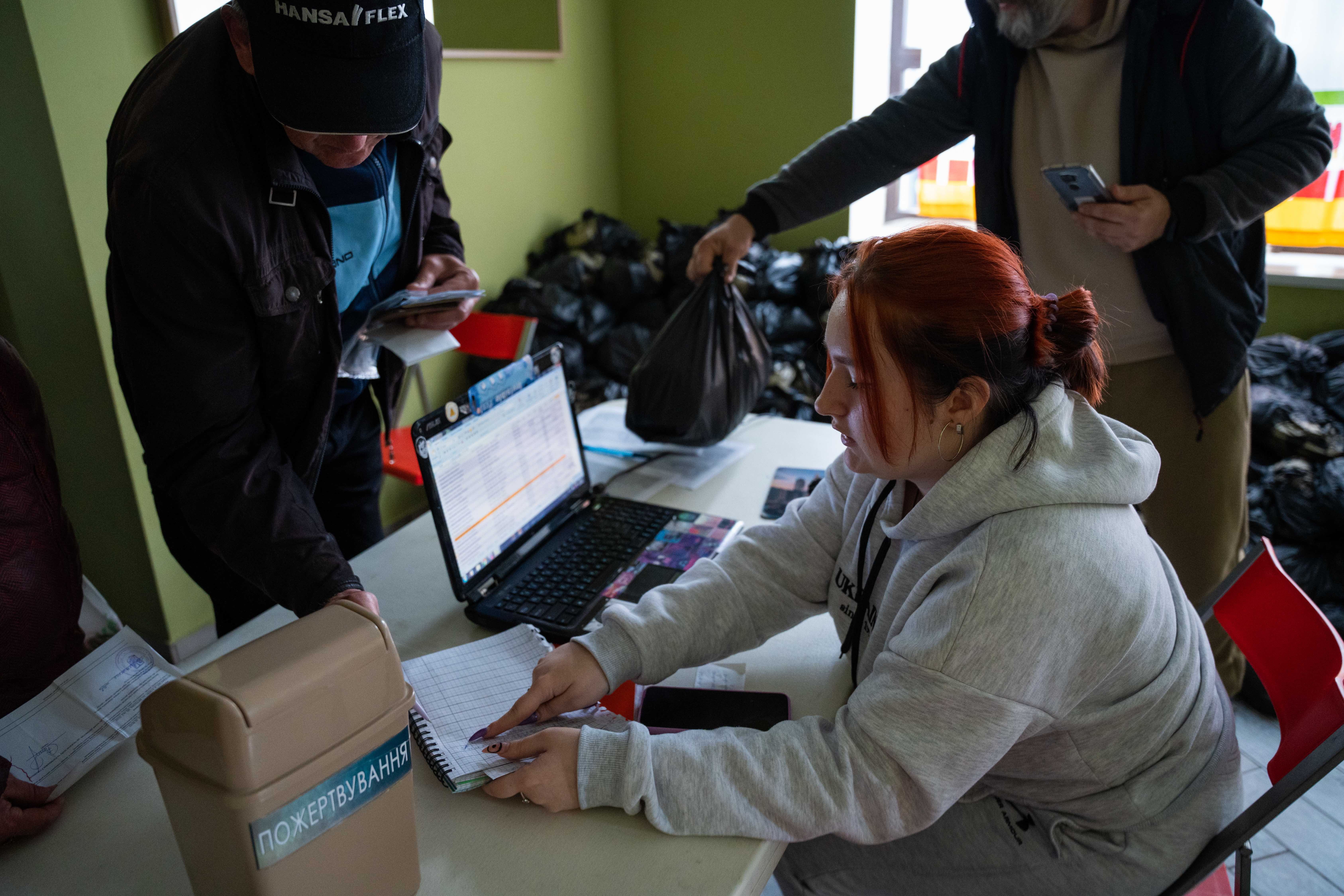 woman helping people receive food donations