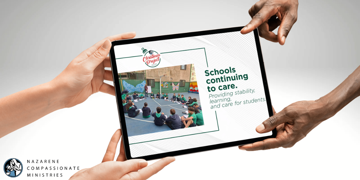one person handing another an ipad with an image of students at a Middle East school