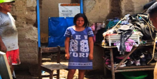 girl standing near damage from cyclone in Peru