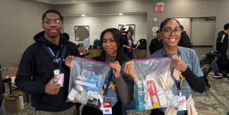 Smiling students holding crisis care kits