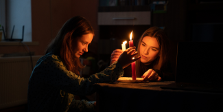 Two teenagers light candles in Ukraine